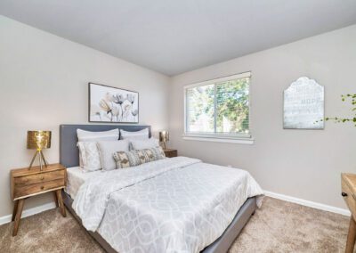 A tranquil bedroom with a well-arranged bed, a modern nightstand, and a window that enhances the room's ambiance.