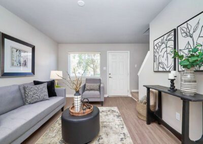 A cozy living room featuring gray couches arranged around a central coffee table, creating a welcoming atmosphere.